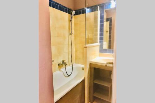 une salle de bain avec une douche, une baignoire et un lavabo dans l'établissement Appartement de standing face à la baie de St-Tropez, vue mer, jardin et piscine., à La Garonnette-Plage