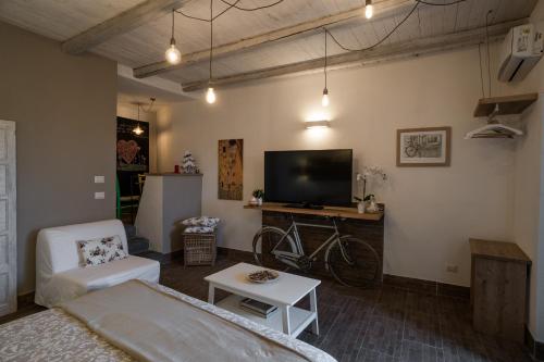 a living room with a couch and a tv at B&B La Casetta in Aci Bonaccorsi