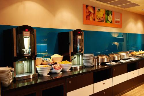 a buffet line with bowls and plates of food at Holiday Inn Express Manchester Airport by IHG in Hale