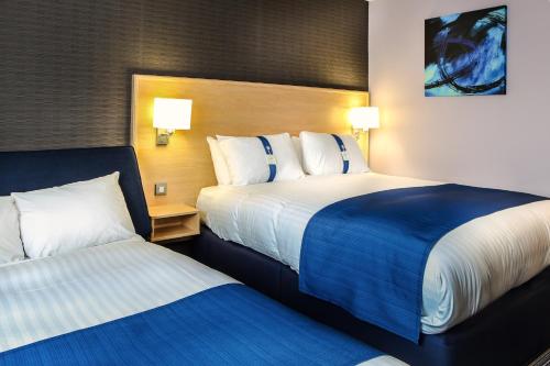 Tempat tidur dalam kamar di Holiday Inn Express Manchester Airport, an IHG Hotel