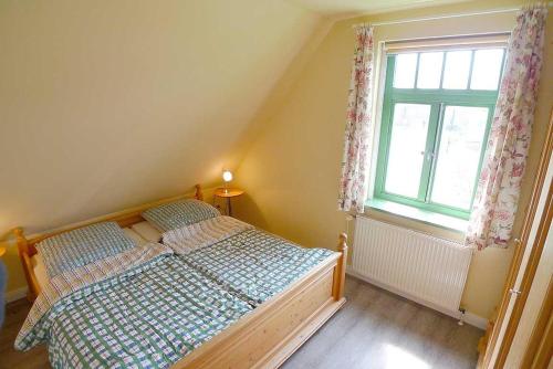 a small bedroom with a bed and a window at Ferienhaussiedlung Strandperlen Weidenhof 3c (Typ II) in Wustrow