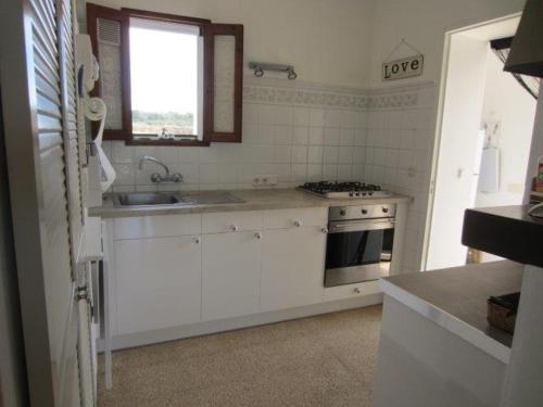 una cucina bianca con lavandino e piano cottura di Casa Laguna ET0490 a La Savina