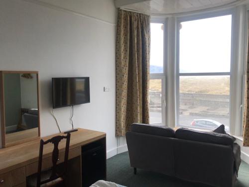 a living room with a couch and a large window at The Sandpiper in Barmouth