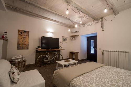 a bedroom with a bed and a tv and a bike at B&B La Casetta in Aci Bonaccorsi
