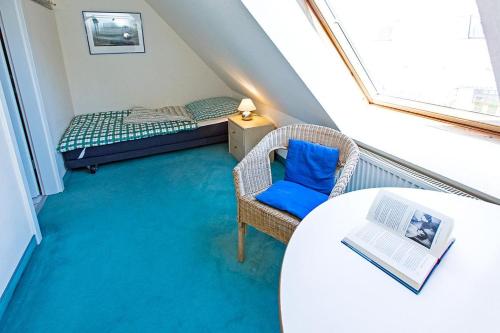 a small attic room with a bed and a chair at Ferienhaussiedlung Strandperlen Sanddornhof 2c (Typ II) in Wustrow