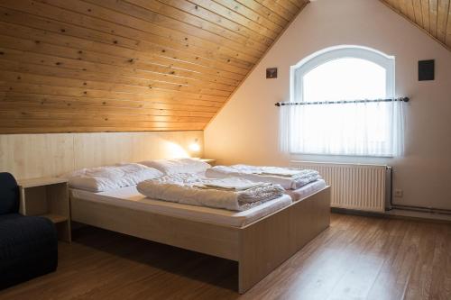 2 camas en una habitación con techo de madera en Vinařství Kratochvíla, en Pasohlávky