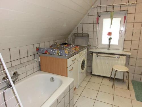 a small bathroom with a tub and a washing machine at Altes Forsthaus in Bad Peterstal-Griesbach