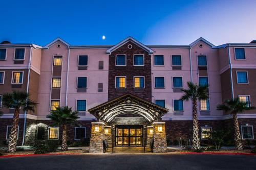 a large building with palm trees in front of it at Staybridge Suites El Paso Airport by IHG in El Paso