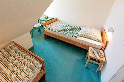 a small bedroom with two beds and a table at Ferienhaussiedlung Strandperlen Küstenhof 1b (Typ V) in Wustrow