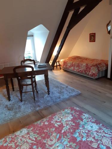 エスカルにあるChambres d'hôtes ''La Grand' Maison''のデスク、ベッド、テーブルが備わる客室です。