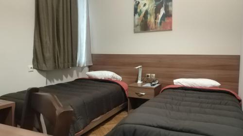 a bedroom with two beds and a window at Ambrosia Suites in Athens