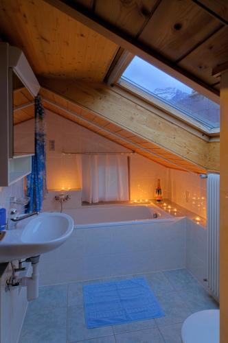 a bathroom with a tub and a sink at Haus Belle-Vue in Saas-Fee