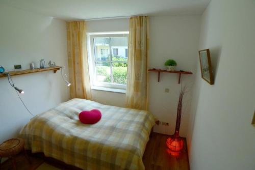 a room with a bed with a pink bowl on it at BIRKENHOF Whg. BH-41 in Wustrow