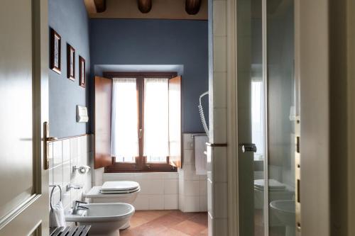 a bathroom with a toilet and a sink and a window at Antico Casale L'impostino in Civitella Marittima