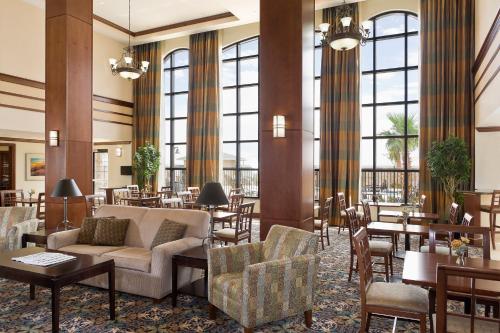 a hotel lobby with tables and chairs and a couch at Staybridge Suites El Paso Airport by IHG in El Paso