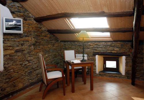 a dining room with a table and a stone fireplace at Hotel y Apartamentos Penarronda Playa in Castropol