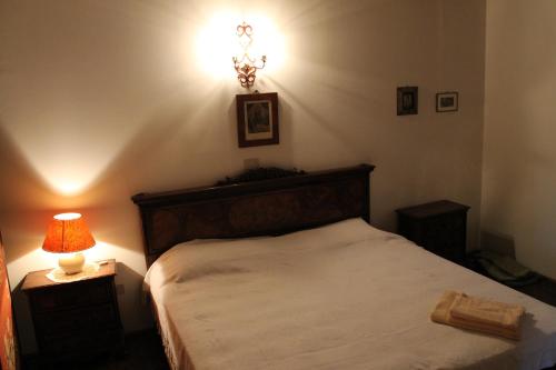 a bedroom with a bed and a lamp on a table at Villa Mainardi Agriturismo in Camino al Tagliamento