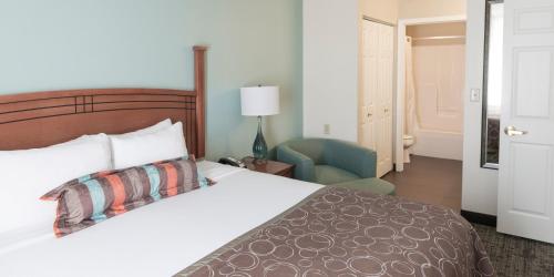 a hotel room with a bed and a chair at Staybridge Suites Fargo by IHG in Fargo