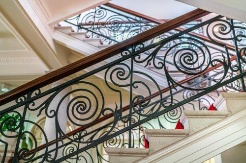 a staircase with wrought iron railings and a stained glass window at Europalace Hotel, BW Signature Collection in Monfalcone