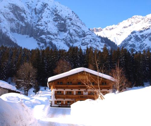 a building covered in snow in front of a mountain at Urblhof in Leutasch