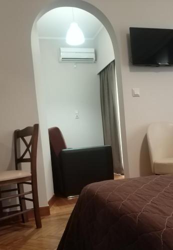 a bedroom with a bed and a chair and a window at Ambrosia Suites in Athens