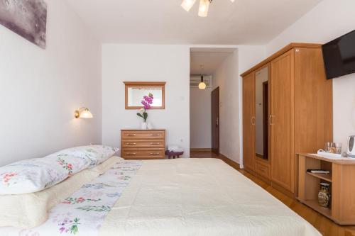 a bedroom with a bed and a dresser at Villa Roko in Tučepi