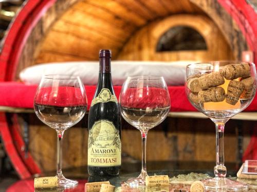 a bottle of wine sitting next to three wine glasses at Al Silter in Capriate San Gervasio