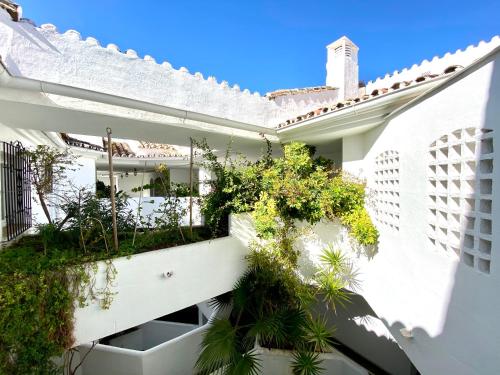 a white building with a balcony with plants at Luxury Puerto Banus Penthouse With Parking & WI-FI in Marbella