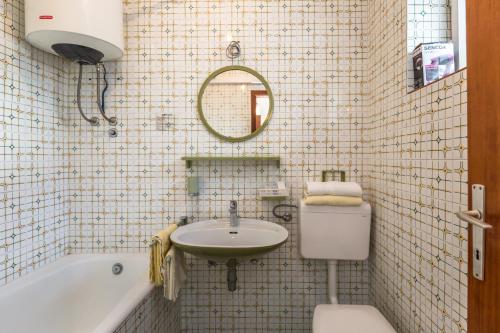a bathroom with a sink and a toilet and a tub at Villa Roko in Tučepi