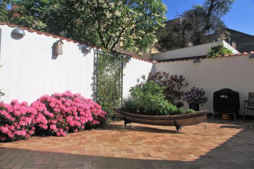 a garden with pink flowers and a bench at Odense City B&B in Odense