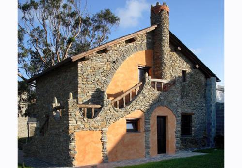 a stone building with a staircase on the side of it at Hotel y Apartamentos Penarronda Playa in Castropol