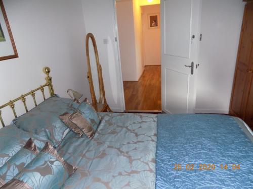 a bedroom with a bed with a blue comforter at Oakdene Apartments in Windermere