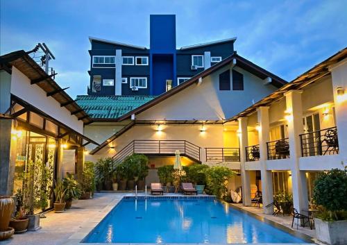 a large house with a swimming pool in front of it at The Nest Resort Patong in Patong Beach
