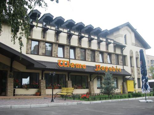 a hotel building with a bench in front of it at Shato Paradis Hotel in Irpin'