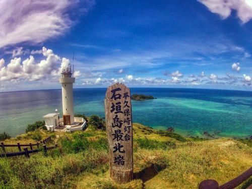 a lighthouse sitting on top of a hill next to the ocean at 435 in Ishigaki Island