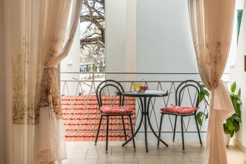 a balcony with a table and two chairs and a window at Villa Roko in Tučepi