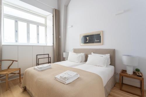 sypialnia z dwoma łóżkami i ręcznikami na górze w obiekcie FLH Cais Sodré Design Duplex - Ribeira 11 w Lizbonie