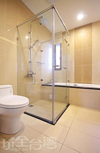 a glass shower in a bathroom with a toilet at Chu V B&B in Yuanshan