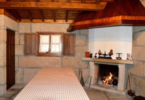 a living room with a fireplace and a table at Quinta do Olival in Vilas Boas