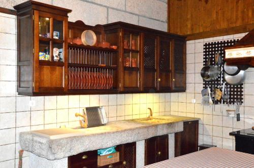 a kitchen with a sink and wooden cabinets at Quinta do Olival in Vilas Boas