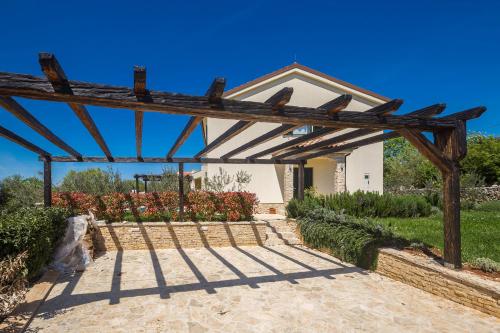 a wooden pergola in front of a house at Holiday house BRZAC in Brzac