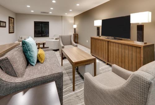 a living room with a couch and a tv at Staybridge Suites - Oklahoma City - Downtown by IHG in Oklahoma City