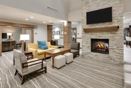 a living room with a fireplace and a tv at Staybridge Suites - Oklahoma City - Downtown by IHG in Oklahoma City