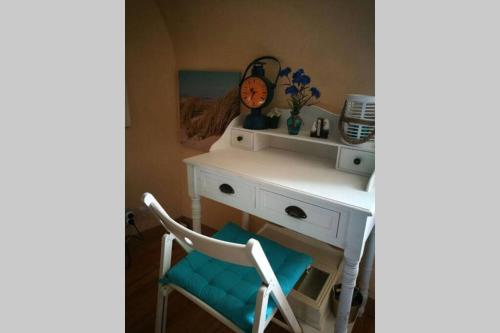 a white desk with a chair and a clock at Charming flat middle of Trouville, 150m from beach in Trouville-sur-Mer