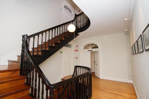 una escalera en una casa con paredes blancas y suelo de madera en The Wine Lodges, en Funchal