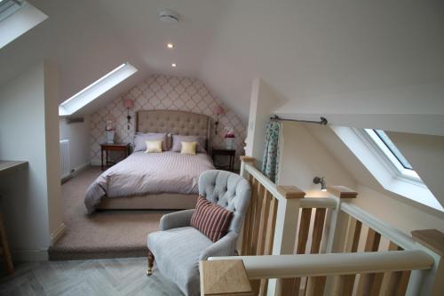 a attic bedroom with a bed and a staircase at Granny's Attic at Cliff House Farm Holiday Cottages, in Whitby