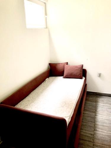a small bed in a room with a window at Apartment on a river avenue in Pančevo