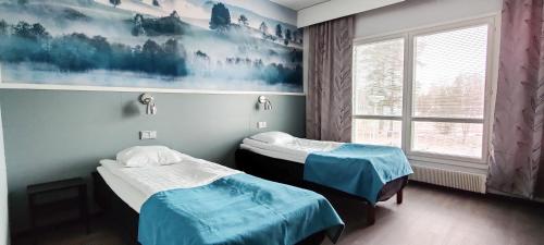 two twin beds in a room with a window at Tanhuvaara Sport Resort in Savonlinna