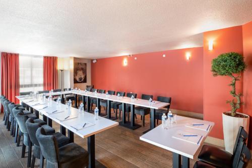 a row of tables and chairs in a room with red walls at SOWELL HOTELS Le Parc & Spa in Briançon