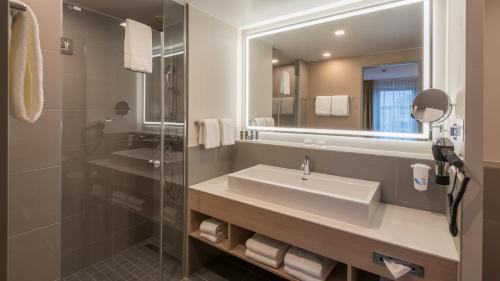 a bathroom with a sink and a mirror at Holiday Inn Düsseldorf City – Toulouser Allee by IHG in Düsseldorf